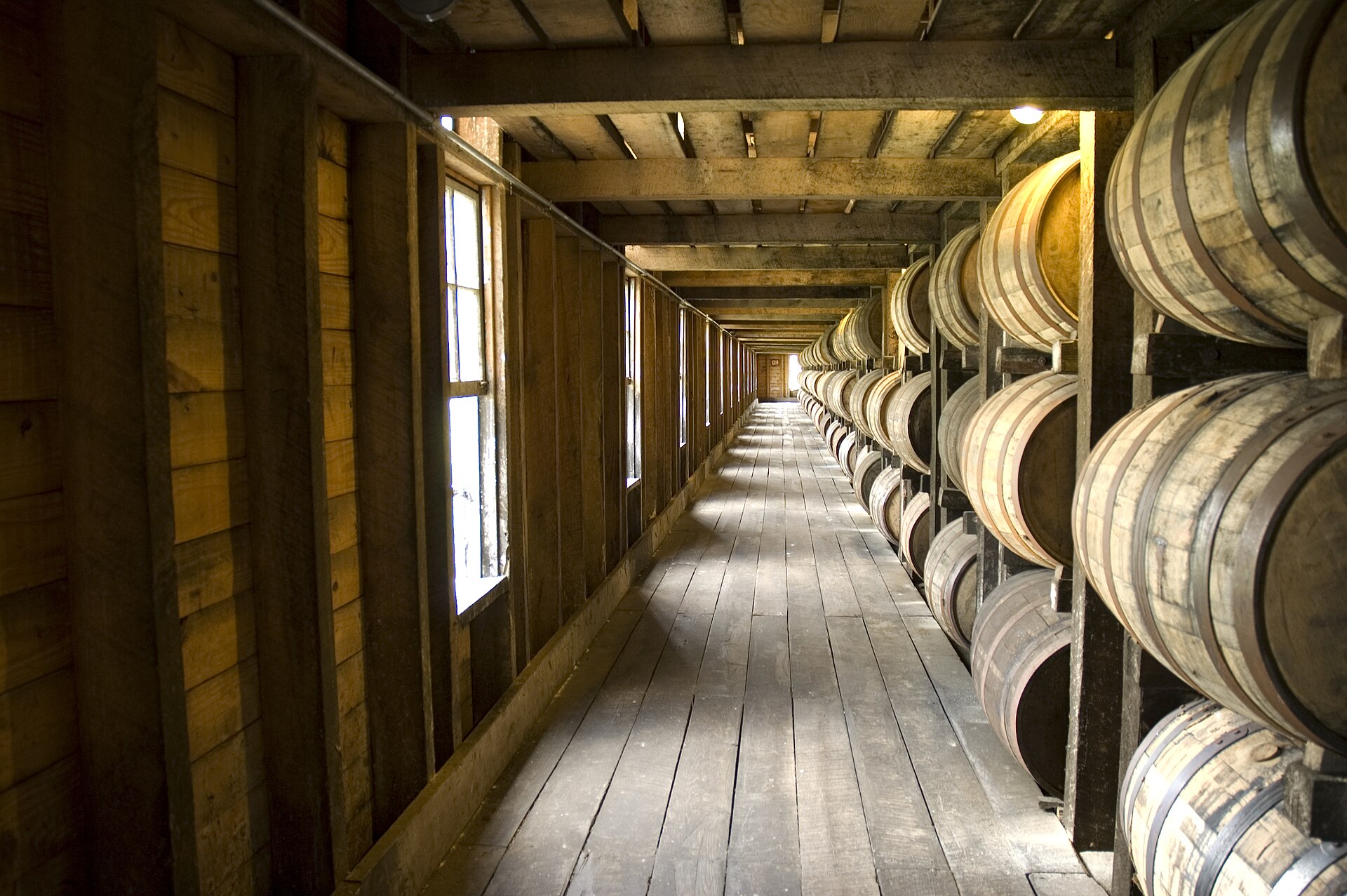 Oak casks resting on timber racks in a maturing warehouse